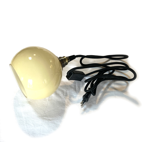 Lampe baladeuse en opaline beige, de forme ronde, parfaite pour une petite touche de douceur dans votre univers déco